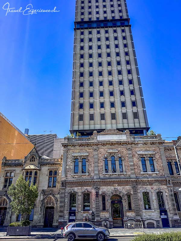 Neueres Hochaus vor/auf altem Backsteingebäude in Adelaide