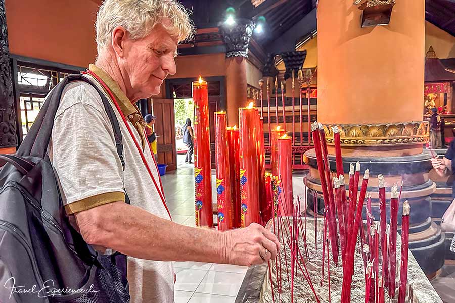 Heinz steckt ein Räucherstäbchen im Tempel Sanggar Agung, Java